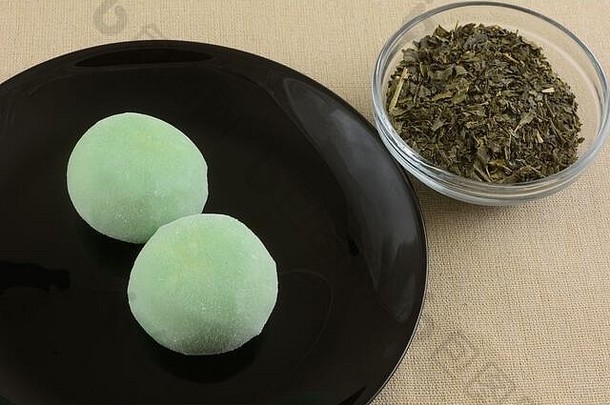 绿色茶冰奶油麻糬球黑色的甜点板绿色茶玻璃碗棕色（的）桌布