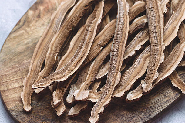 片干灵芝蘑菇被称为灵芝灵芝清明的木董事会灰色的背景中国人传统的医学产品