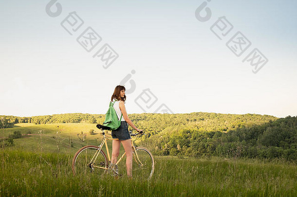 女孩自行车享受美丽的农村景观