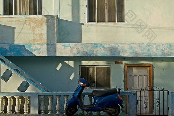 停蓝色的踏板车前面衰落蓝色的建筑