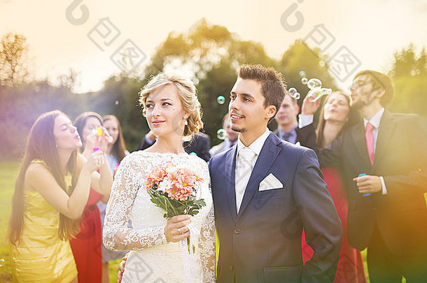 年轻的新婚夫妇享受<strong>浪漫</strong>的时刻婚礼接待婚礼客人背景吹泡沫