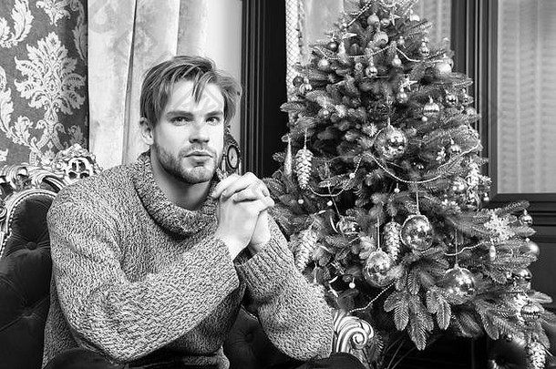 男子气概毛衣圣诞节树生活房间一年夏娃聚会，派对冬天时尚风格概念假期准备庆祝活动男人。坐红色的扶手椅圣诞节树