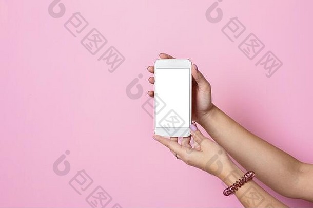 女手持有移动电话白色屏幕粉红色的背景一边视图