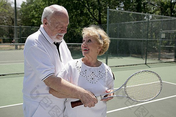 高级夫妇玩网球显示控制网拍