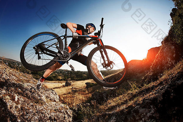 专业骑自行车的人采取自行车岩石小道晚上极端的体育运动概念低角鱼眼