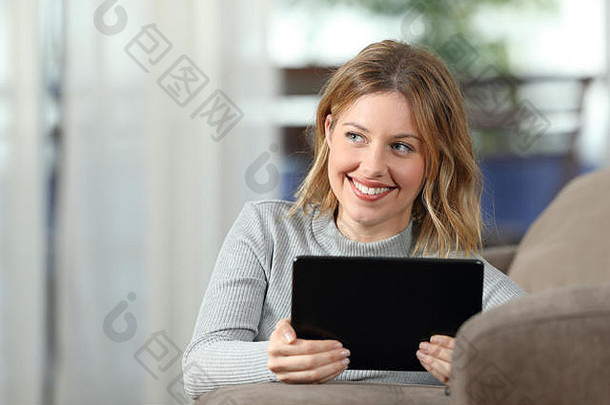 前面视图快乐女人思考持有平板电脑说谎沙发上生活房间首页
