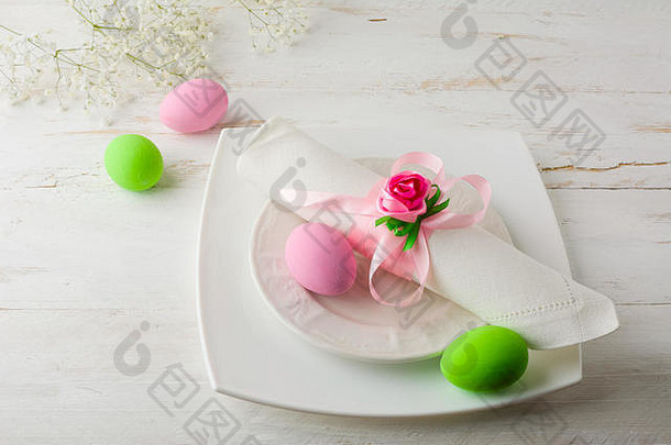 粉红色的绿色复活节表格的地方设置板餐巾粉红色的绿色装饰复活节鸡蛋白色木背景