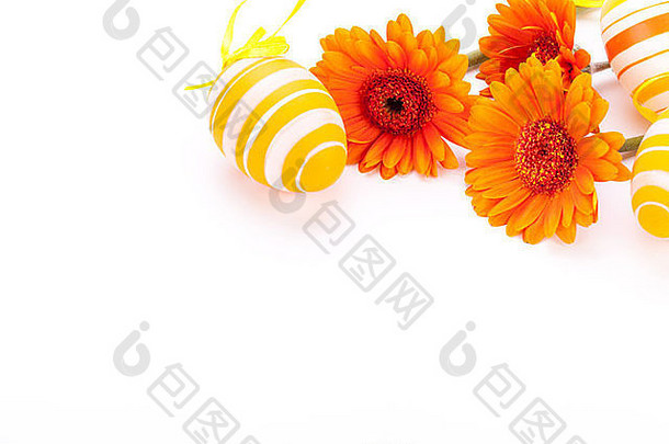 色彩鲜艳的黄色的手装饰传统的复活节鸡蛋条纹波尔卡点模式安排色彩鲜艳的橙色非洲菊雏菊装饰丝带白色Copyspace