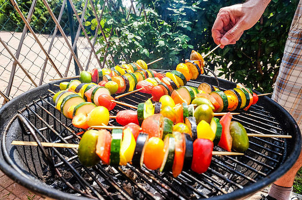 烹饪烧烤蔬菜西葫芦番茄佩皮尔串烧烤在户外阳光明媚的放松周末