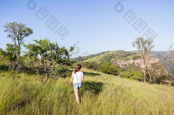 女孩少年走山坡上草脚小径荒野徒步旅行地形