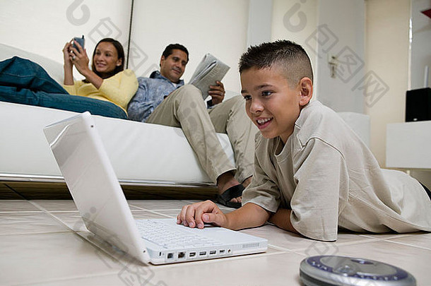 男孩移动PC地板上生活房间妈妈。父亲沙发地面视图