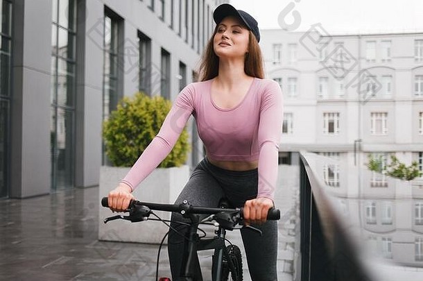运动年轻的女人游乐设施自行车城市小巷