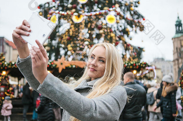 美丽的年轻的金发女郎女人女孩自拍拍摄圣诞节树圣诞节假期小镇广场布拉格捷克共和国