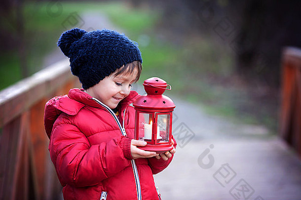 甜蜜的孩子持有红色的灯笼公园阳光明媚的冬天一天在户外