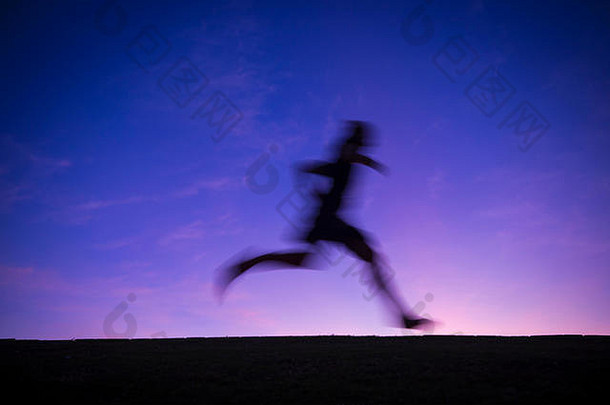 轮廓跑步者大步完整的长度运动模糊明亮彩色的日出天空