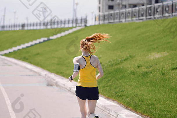 年轻的健康的生活方式女人运行日出路女孩运行沥青路女孩运行黄色的体育衬衫