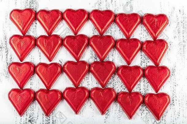 心形状的巧克力糖果包装红色的色彩斑斓的箔情人节一天情人节图像白色木背景
