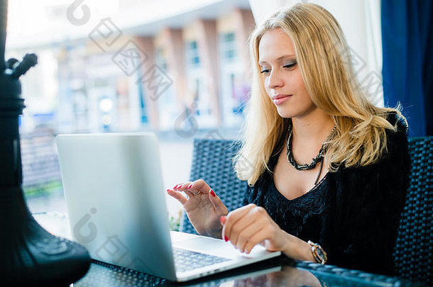 年轻的华丽的女人喝咖啡坐着开放移动PC电脑在户外女自由职业者工作笔记本人行道上咖啡馆漂亮的学生女孩冲浪网阳台