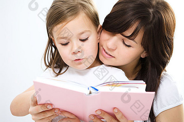 妈妈。阅读书女儿室内拍摄