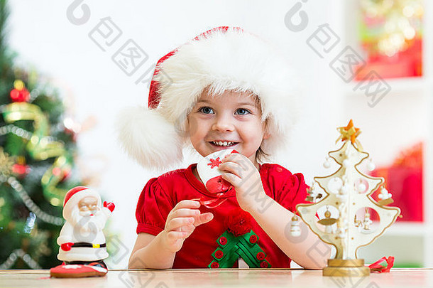 女孩穿节日红色的圣诞老人他圣诞节饼干