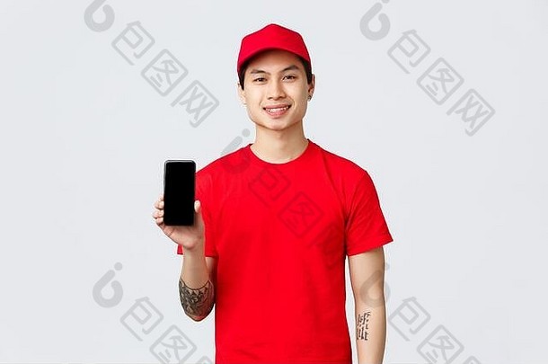 交付应用程序在线购物航运概念微笑交付的家伙红色的统一的帽t恤显示移动电话屏幕建议