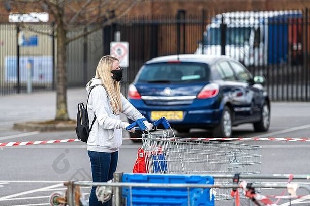 购物者等待特易购超市切尔滕纳姆同时政府社会距离的指导方针