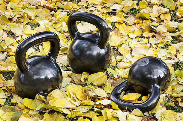 重铁壶铃在户外秋天风景户外健身概念