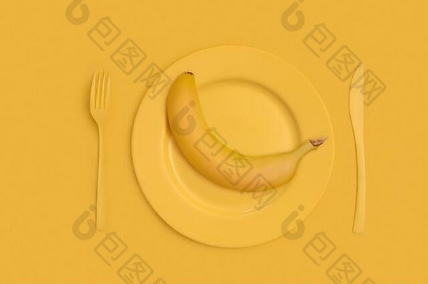 黄色的多汁的香蕉前黄色的板刀叉黄色的背景视图前