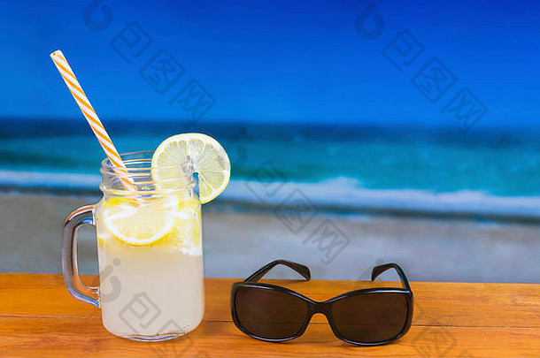 让人耳目一新柠檬喝木表格太阳镜焦点海滩海洋背景Copyspace