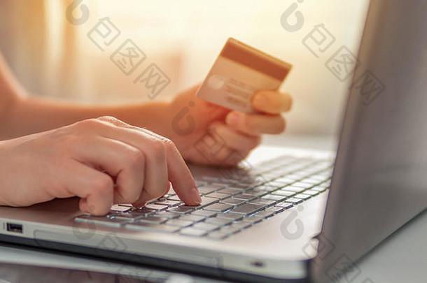 在线购物概念特写镜头女人的手持有信贷卡移动PC键盘在线购物