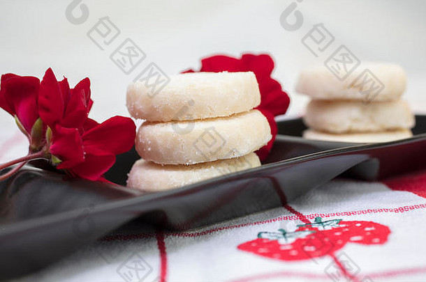 柠檬饼干堆放镀红色的白色表格布斯卓刺绣花