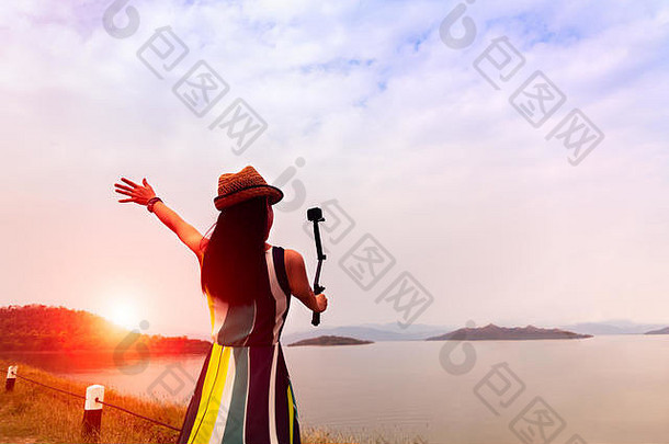 旅行者女人享受自拍美丽的日落湖山背景