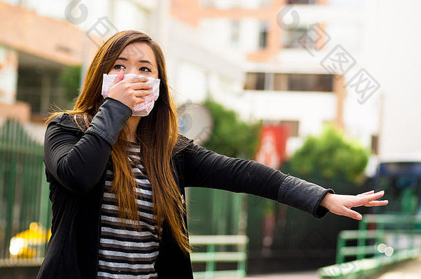 年轻的女人持有保护面具手街城市空气污染出租车城市背景
