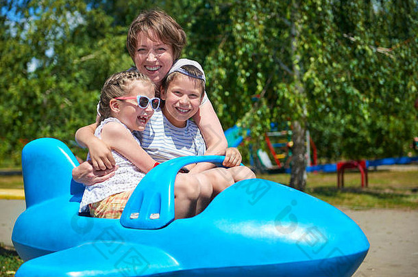 孩子女人飞蓝色的飞机吸引力城市公园快乐家庭夏天假期概念