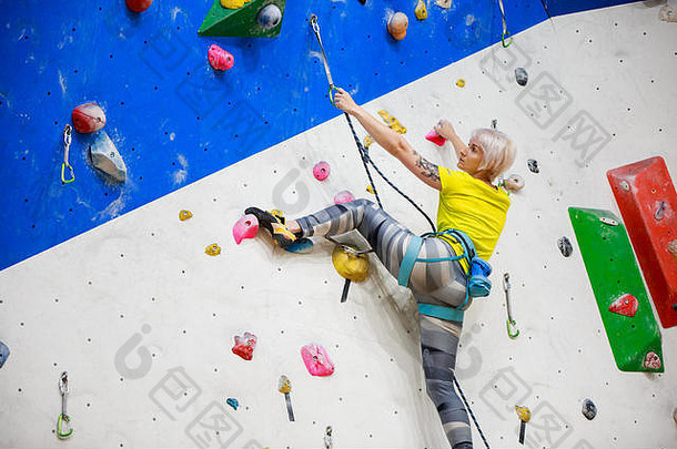 照片回来年轻的ahtlete女孩黄色的t恤打乱<strong>墙</strong>攀爬锻炼