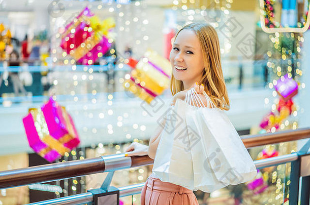 年轻的女人圣诞节购物中心圣诞节购物美买圣诞节晚上购物折扣