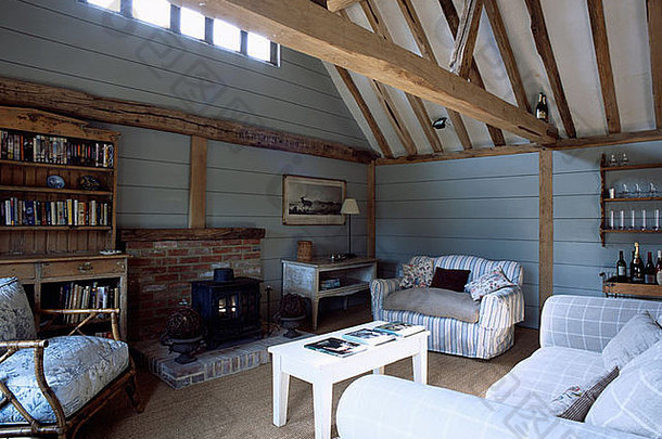 大木天花板梁舒适的沙发苍白的蓝色的精品转换生活房间燃木炉子