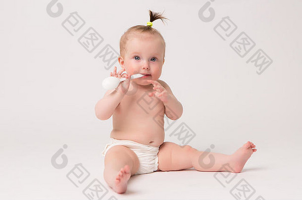 婴儿女孩轻咬婴儿塑料勺子婴儿食物概念