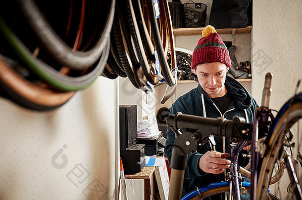 年轻的男人。工作周期商店修复自行车
