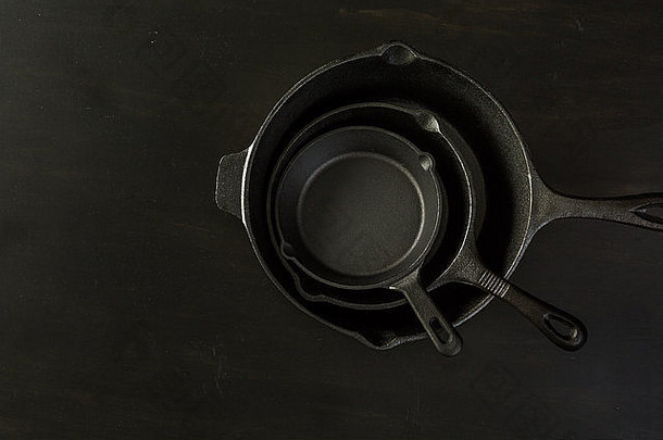 传统的投铁长柄平底煎锅黑色的木表格