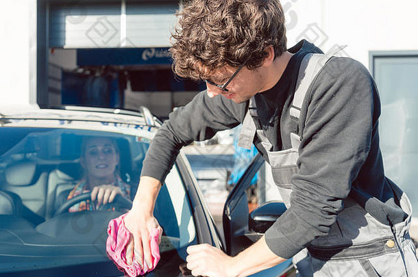 勤奋的服务男人。帮助女人清洁车商业洗