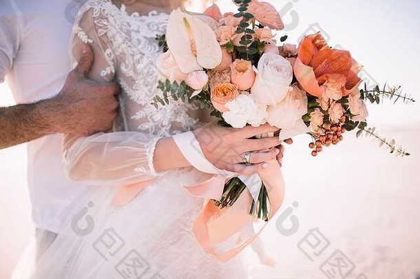 特写镜头新娘的花束孤挺花花烛属植物玫瑰康乃馨桉树白桃阴影新娘花边白色衣服