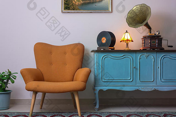 古董室内复古的橙色扶手椅古董木光蓝色的餐具柜留声机留声机乙烯基记录照亮表格灯