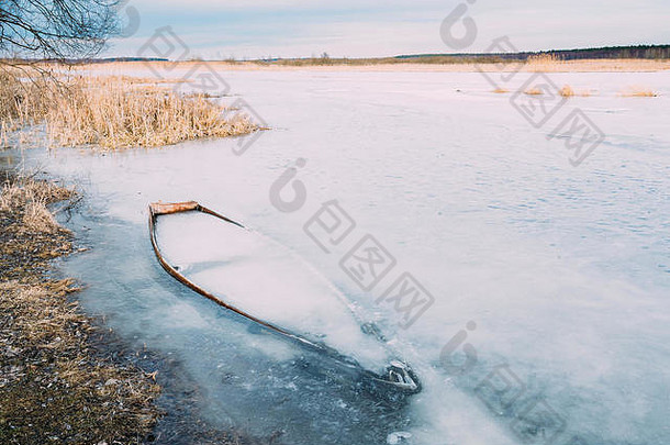 冻冰河湖池塘木船被遗弃的划船钓鱼船冬天河离弃船