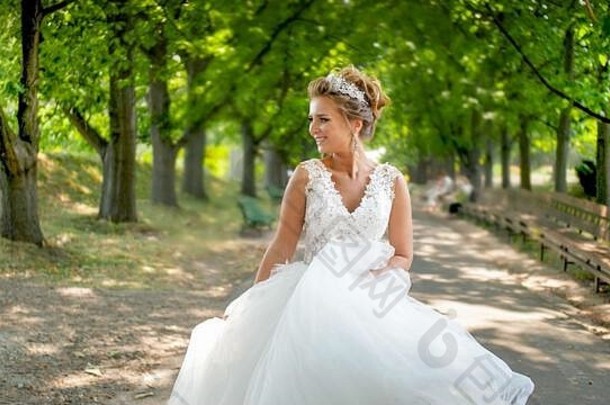 肖像快乐微笑年轻的新娘白色衣服走美丽的小巷公园