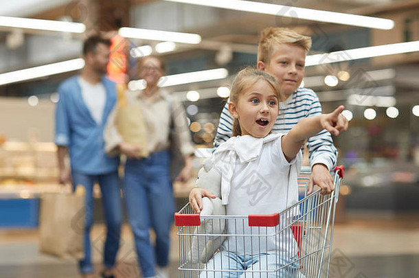 肖像兴奋孩子们骑购物车超市复制速度