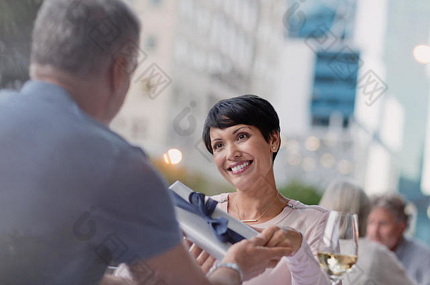 微笑女人接收礼物丈夫城市人行道上咖啡馆