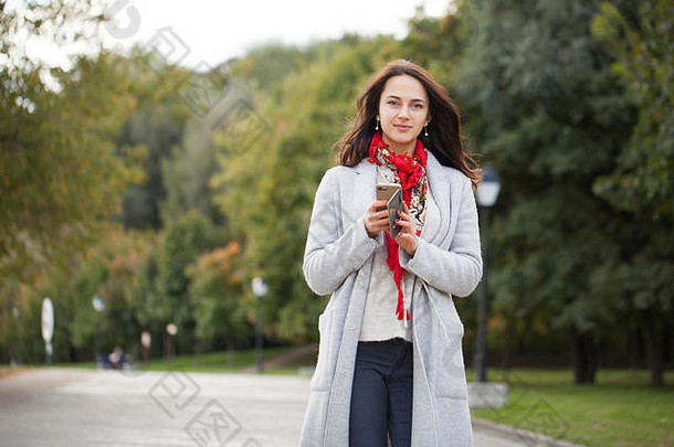 美丽的年轻的浅黑肤色的女人女人调用电话秋天公园