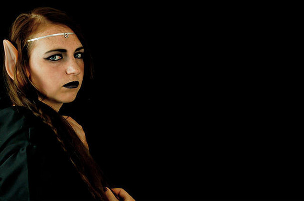 年轻的女人穿着精灵黑色的连帽袍长头发指出精灵耳朵