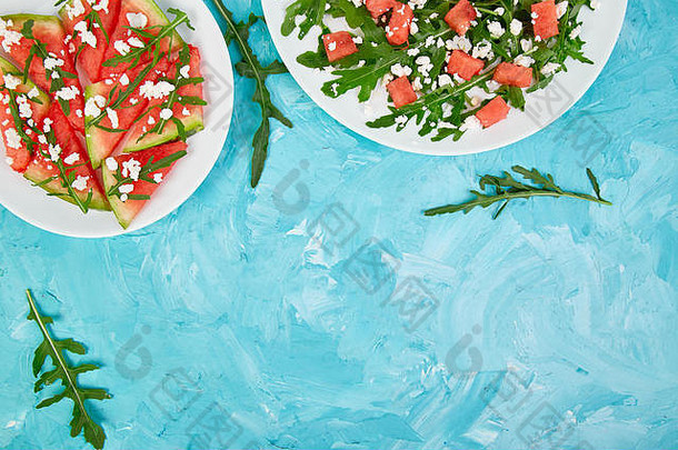 新鲜的夏天西瓜沙拉羊奶酪芝麻菜蓝色的表格背景素食主义者食物饮食素食者前视图平躺复制空间